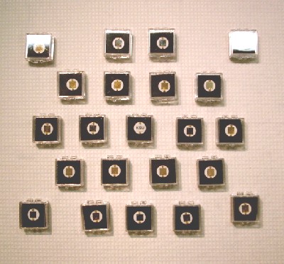 A set of perforated GaAs detectors prepared for testing. The detectors are coated with various combinations of B and LiF. After being coated with a proprietary encapsulate, these detectors will be sent to a DOE national laboratory for deployment. 