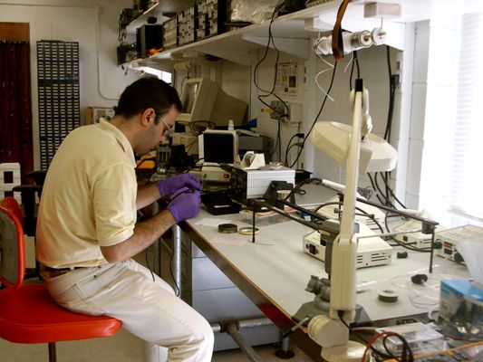 Alireza Kargar works on a circuit for a CdZnTe Frisch ring detector.